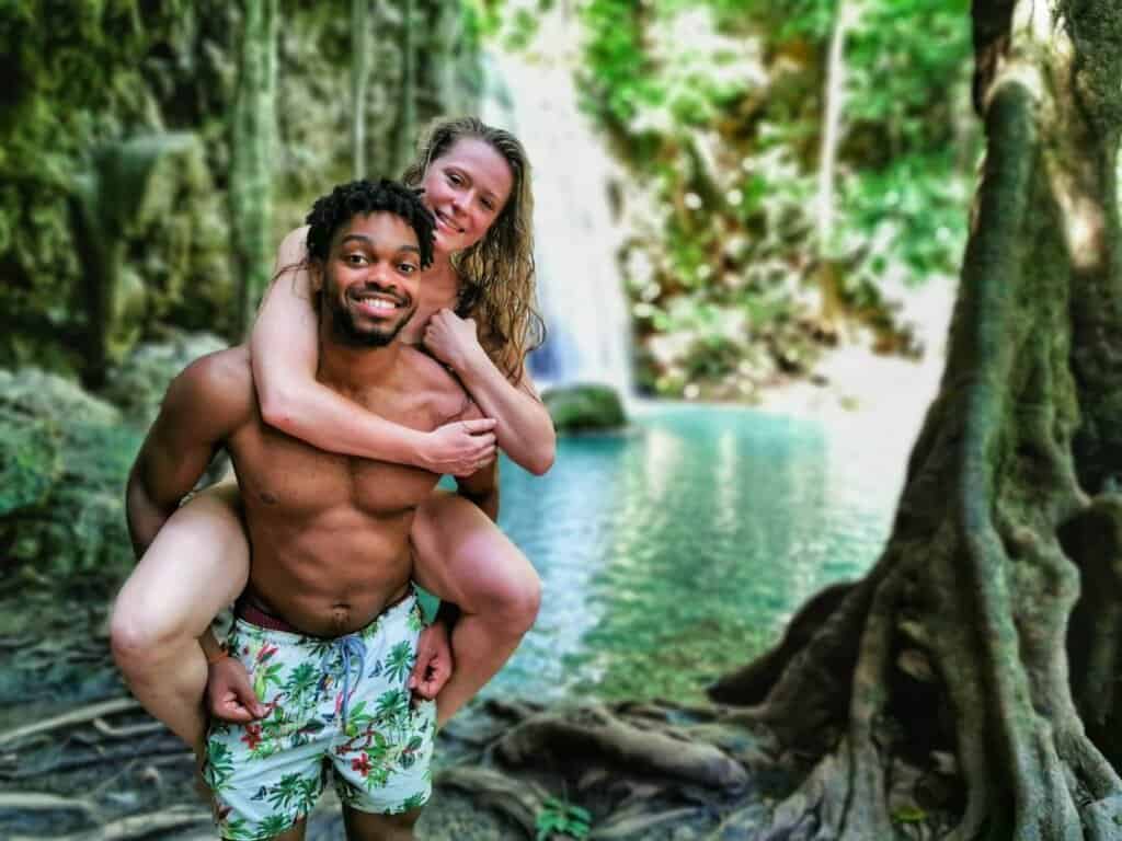 Two Frequent Flyers. A picture of Beth and Denz at a waterfall. Travel blog. Travel Vlog. Best things to do around the world.