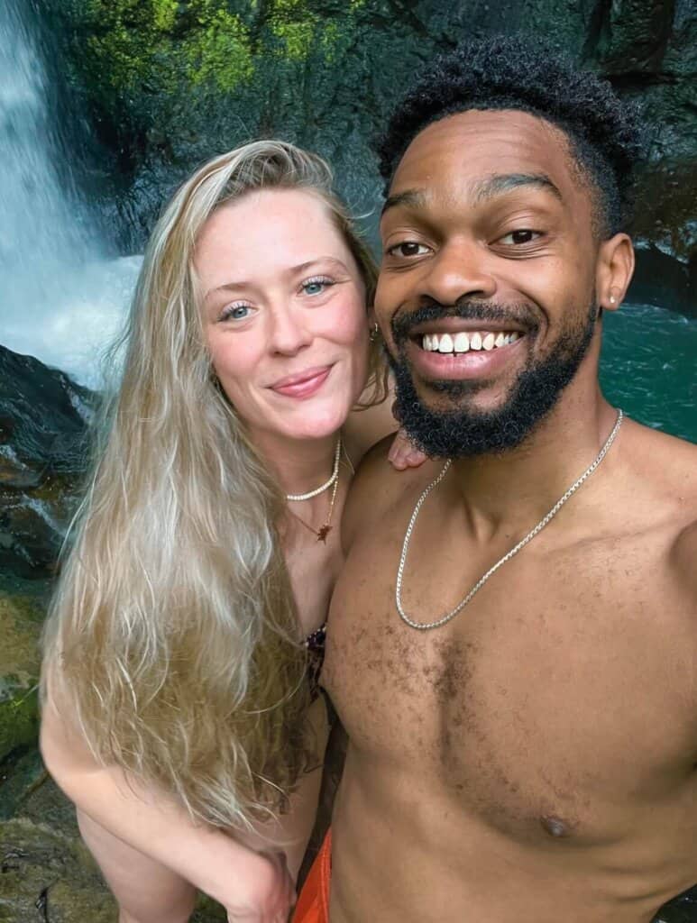 Beth and Denz at a waterfall in Bali. Part of a blog sharing free travel guides.