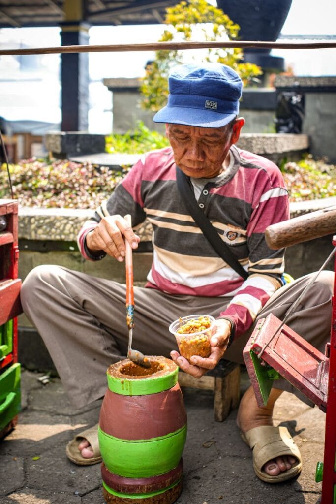 Street food vendor preparing local dish in Indonesia.